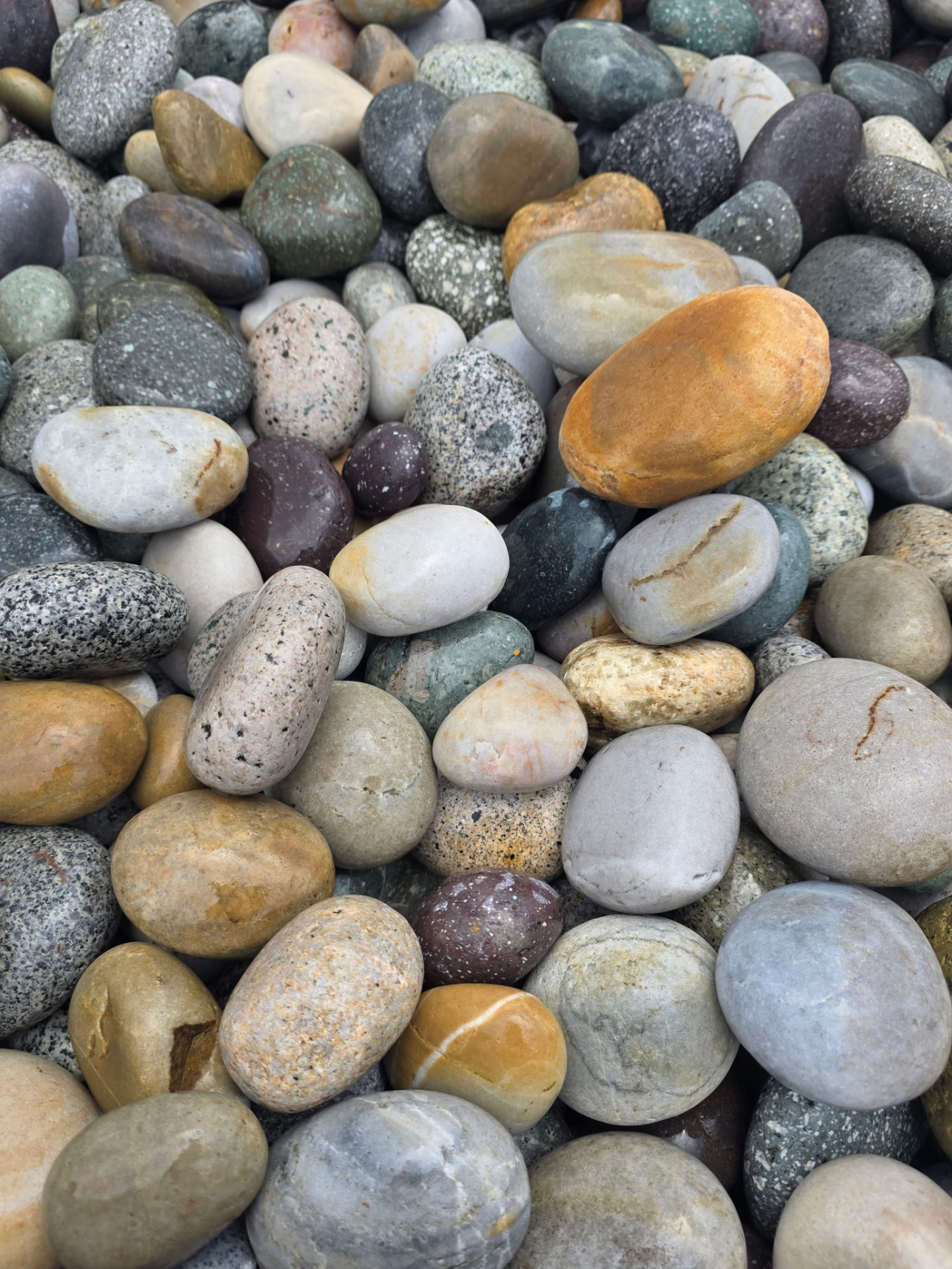 Assorted polished Peruvian beach pebbles in warm and cool tones